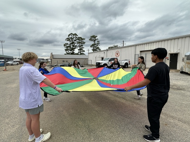 students holding a colorful parachute