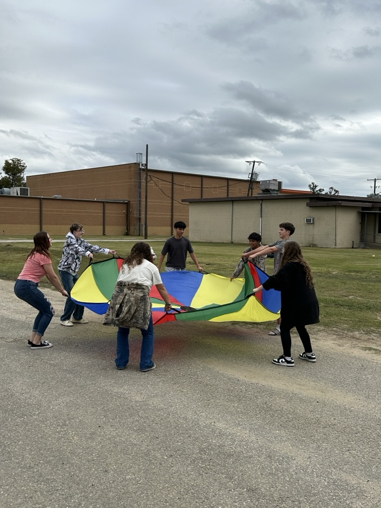 students holding a colorful parachute