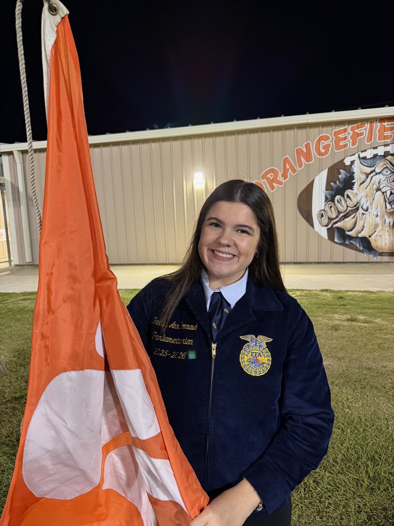 student in FFA jacket raising the Orangefield flag