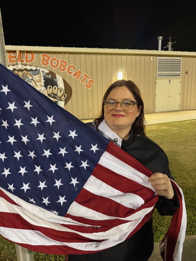 student in FFA jacket raising the American flag