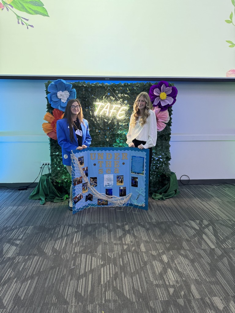 two students with blue bulletin board