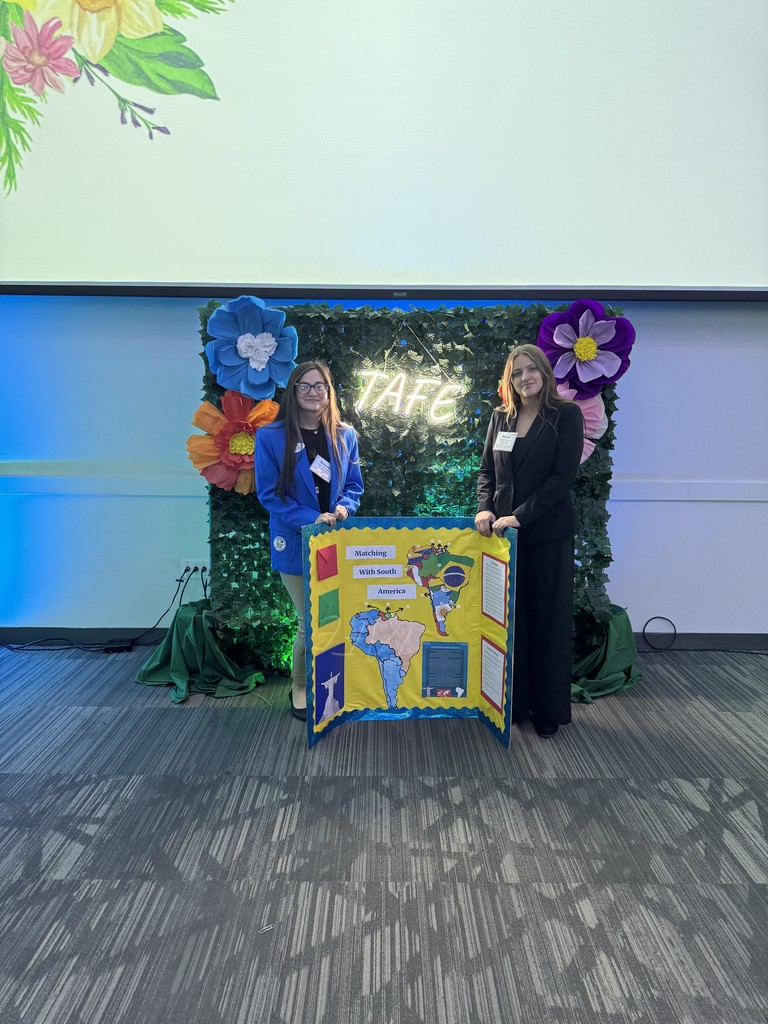 two students with yellow bulletin board