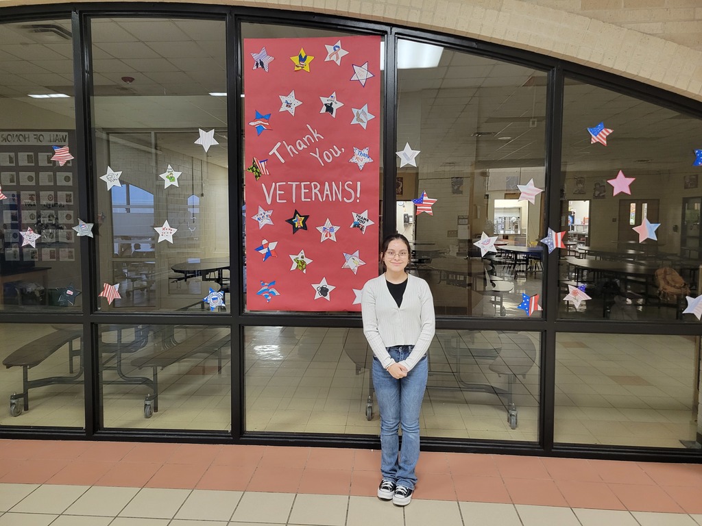 A student poses in front of painted a stars in honor of veteran's day.