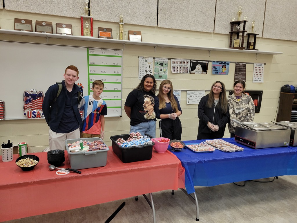 StuCo students pose in front of the veteran's breakfast.