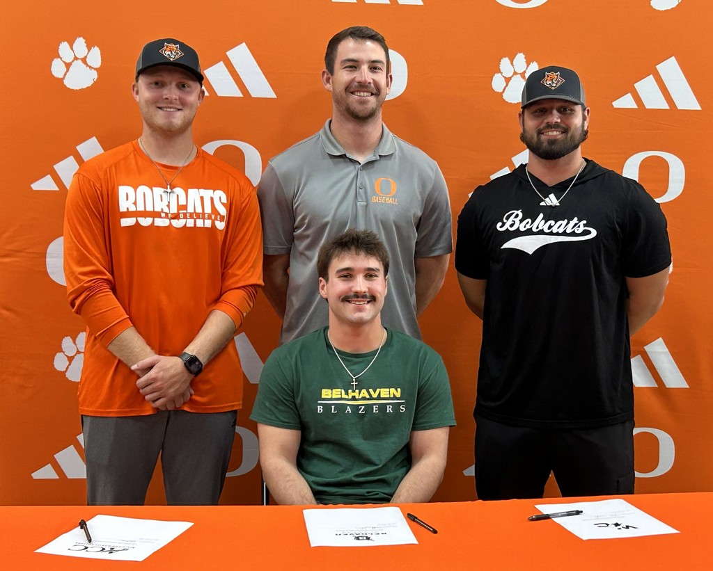 three coaches and student sitting in a green shirt