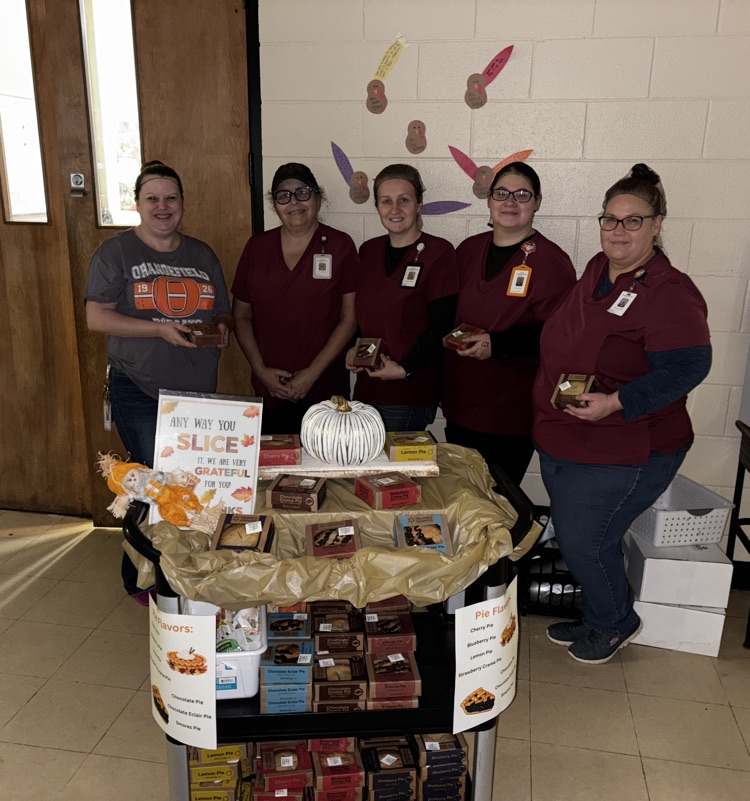 OJH Staff pose for a picture in front of the jolly trolly with their pies.