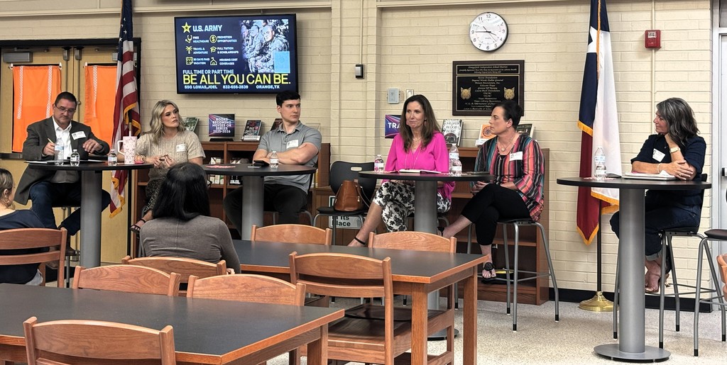 student sitting at library tables listening to guest speakers