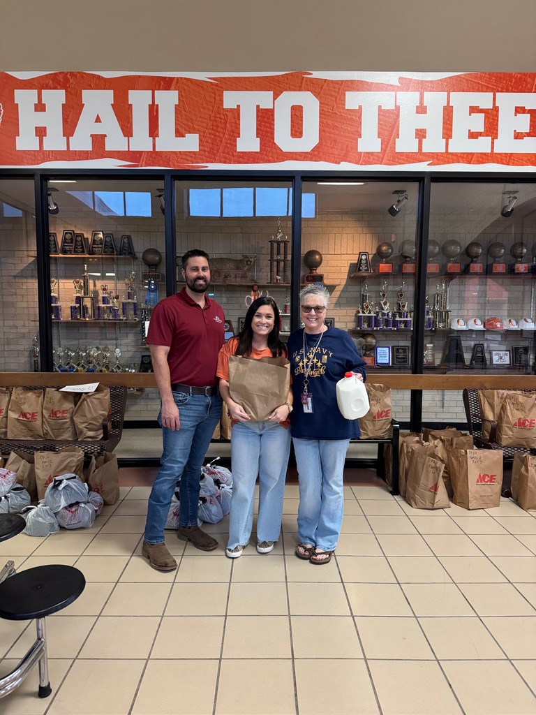 Dusty Stark, Kayla Stark, and Ann Folsom pose with the food donated to help bobcat students have a Thanksgiving dinner.
