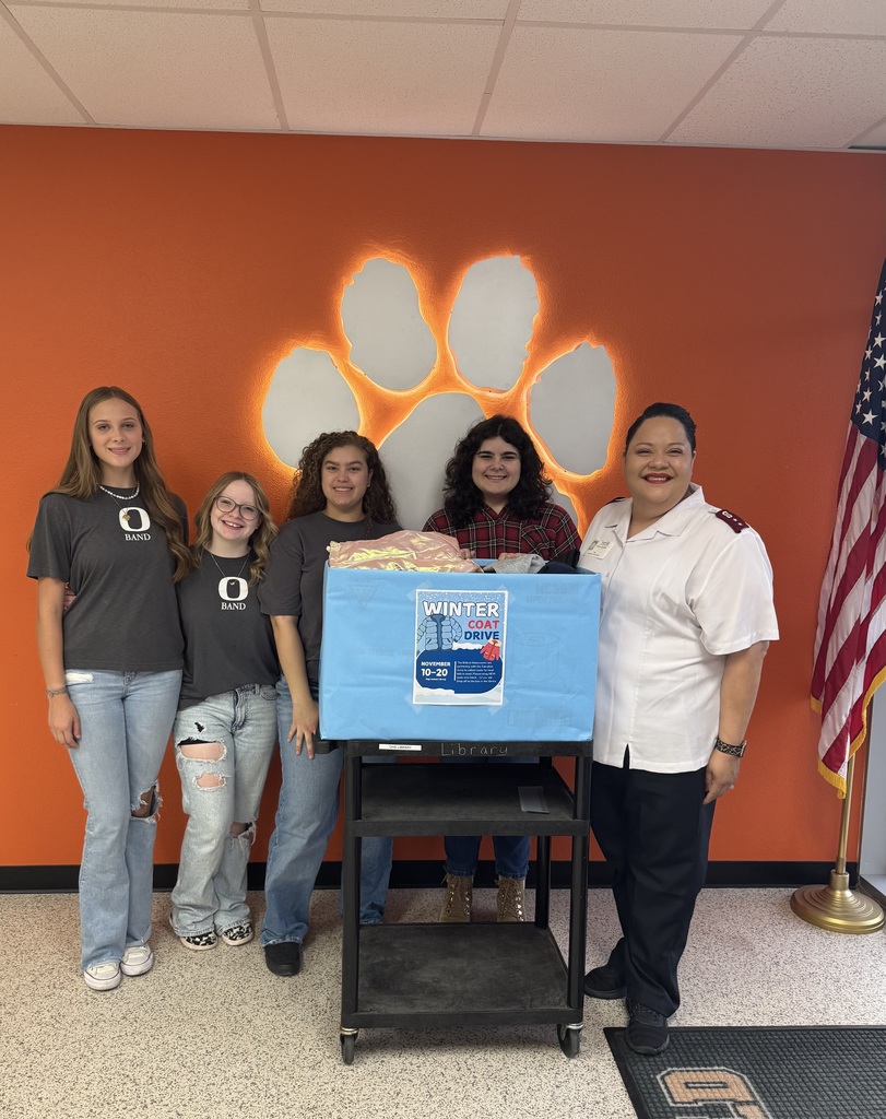 four students with a box of coats in front of a paw