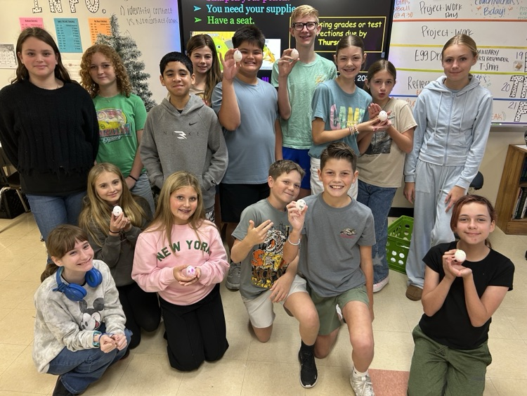students posing with their egg contraptions.