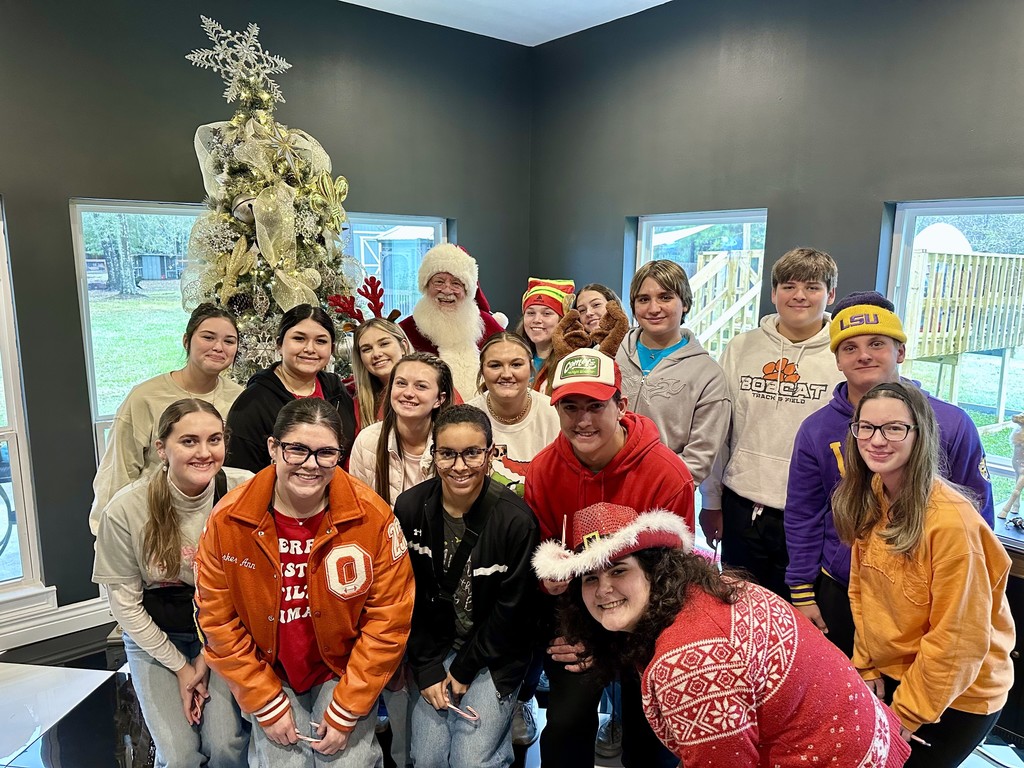students with Santa in front of a Christmas tree