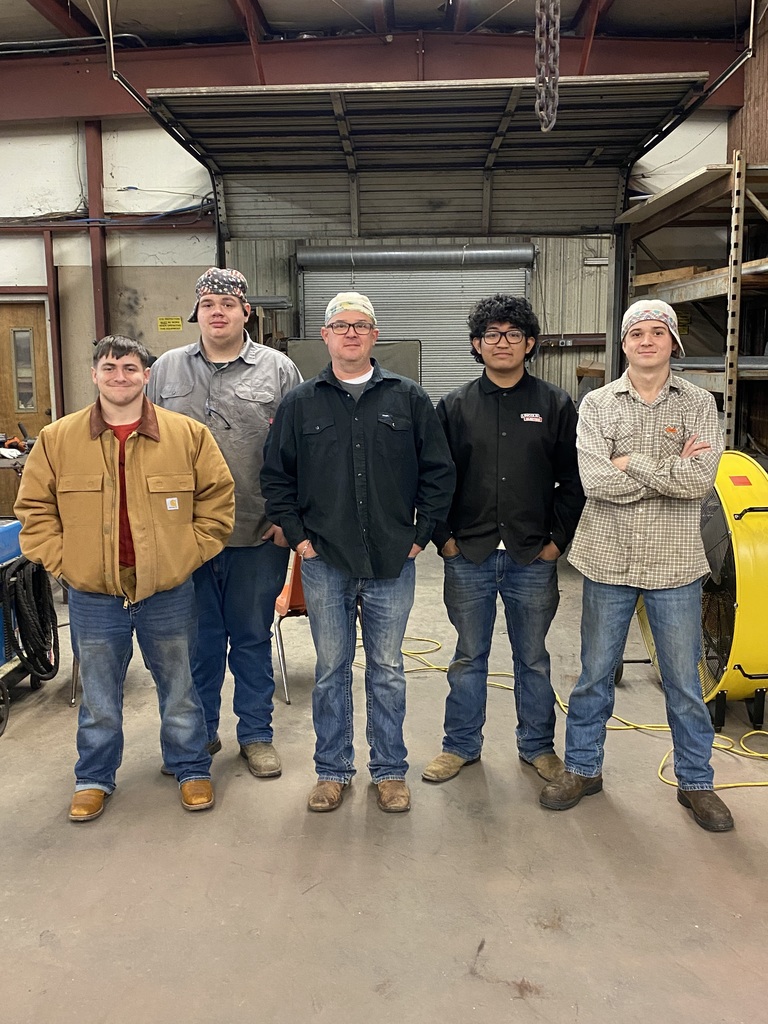 students with volunteer in welding shop