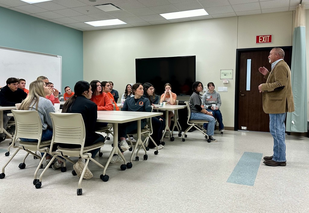 students seated listening to a guest speaker