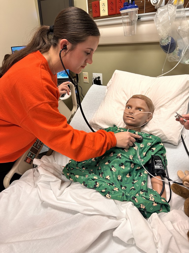 student taking heartrate of a dummy