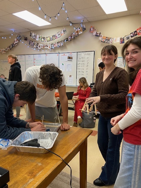 four students building catapult