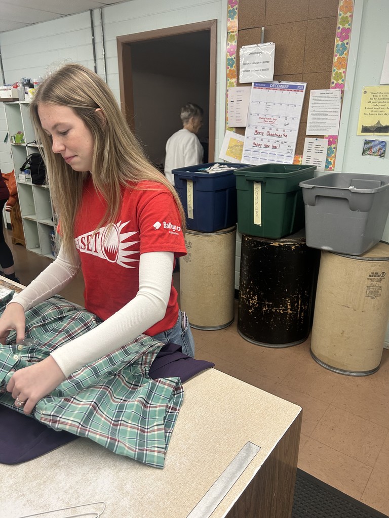 one student folding shirts
