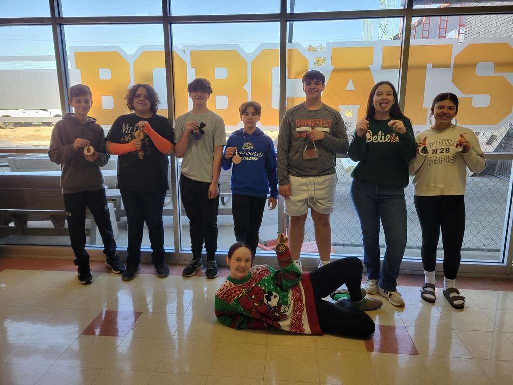 8th grade students pose with their Christmas ornaments.