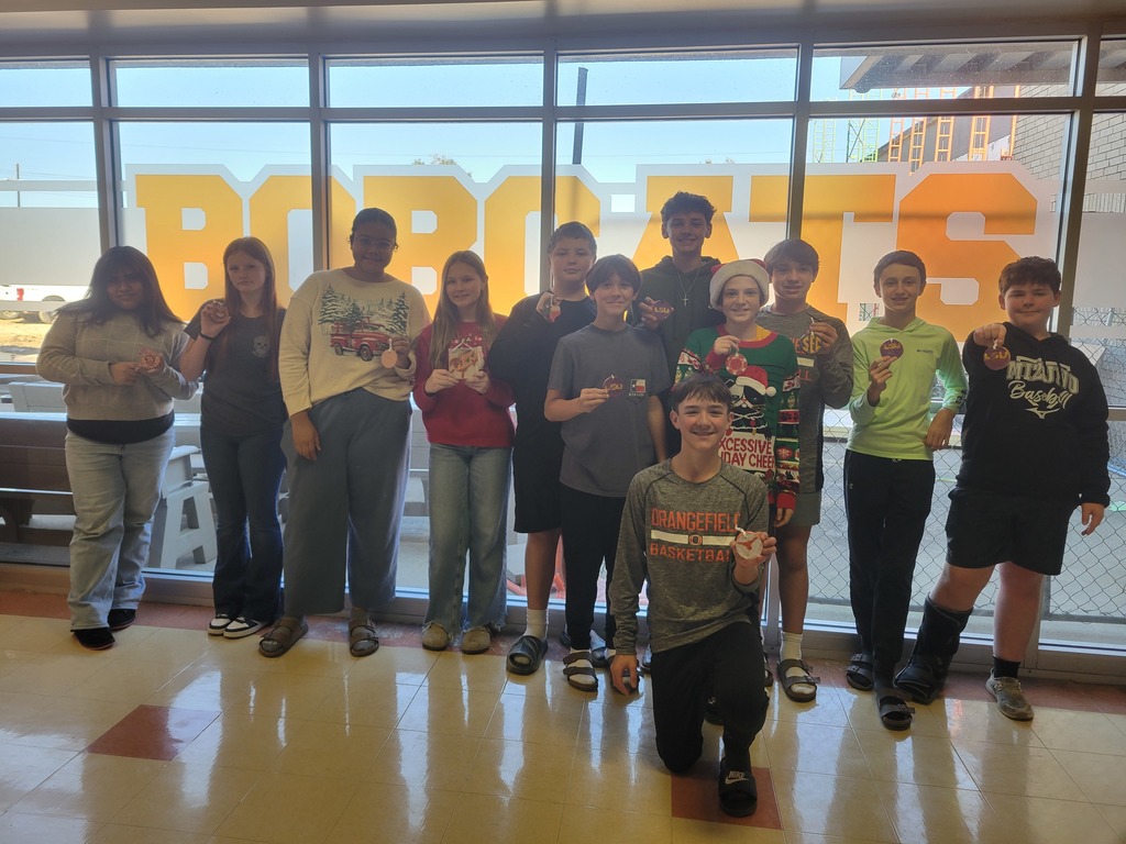 8th grade students pose with their Christmas ornaments.