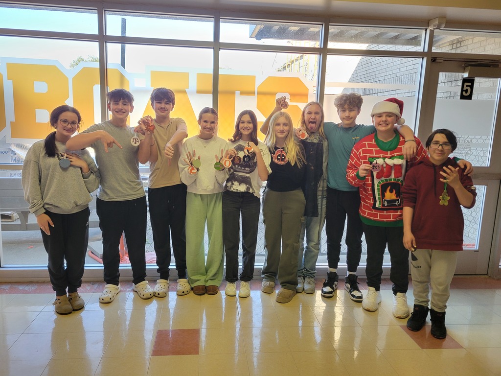 8th grade students pose with their Christmas ornaments.
