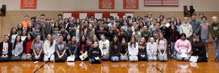 many students sitting together in gym bleachers
