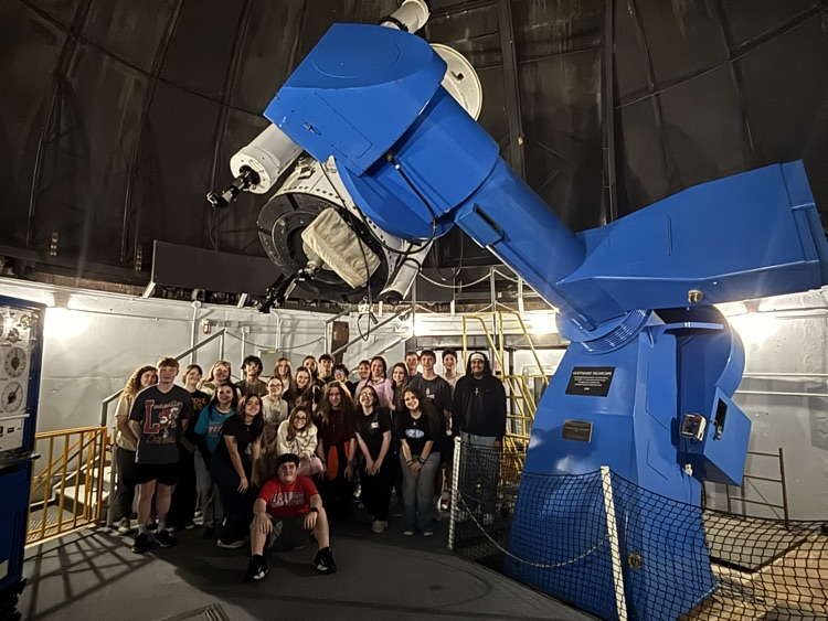 students on the floor of the telescope dome