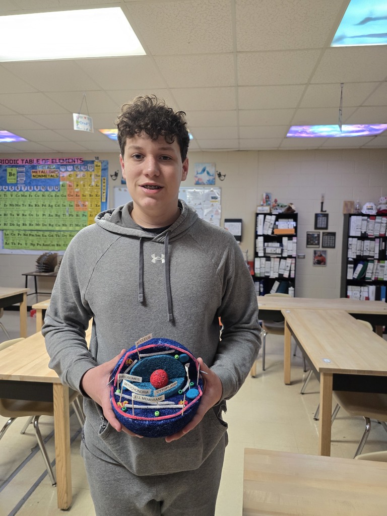 8th grade student posing with their science project.
