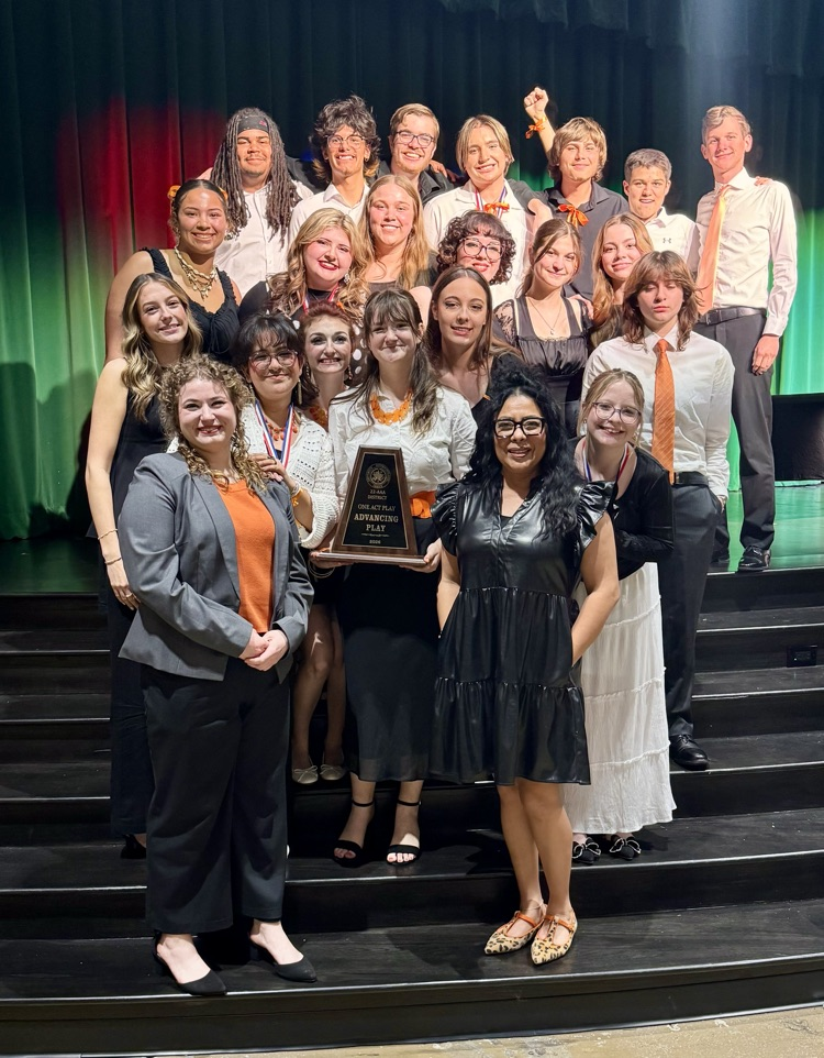 Students on a stage with a trophy  