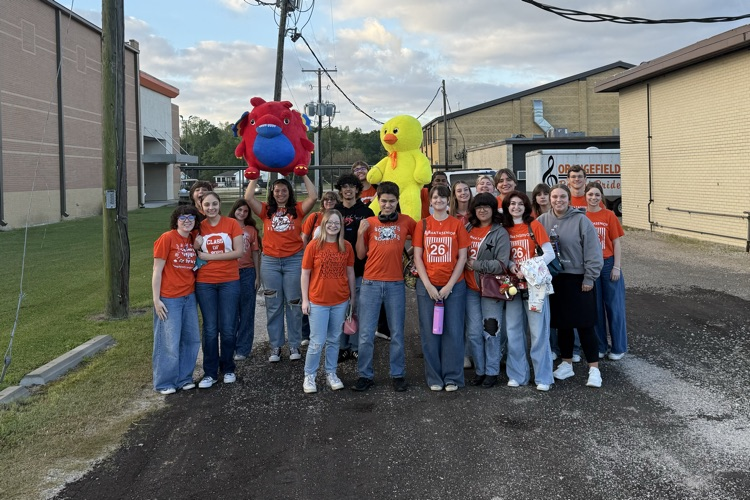 students posing outside with orange shirts on