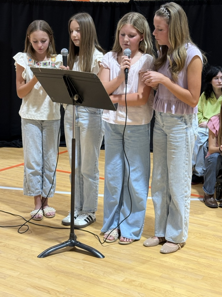 Choir students are photographed singing.