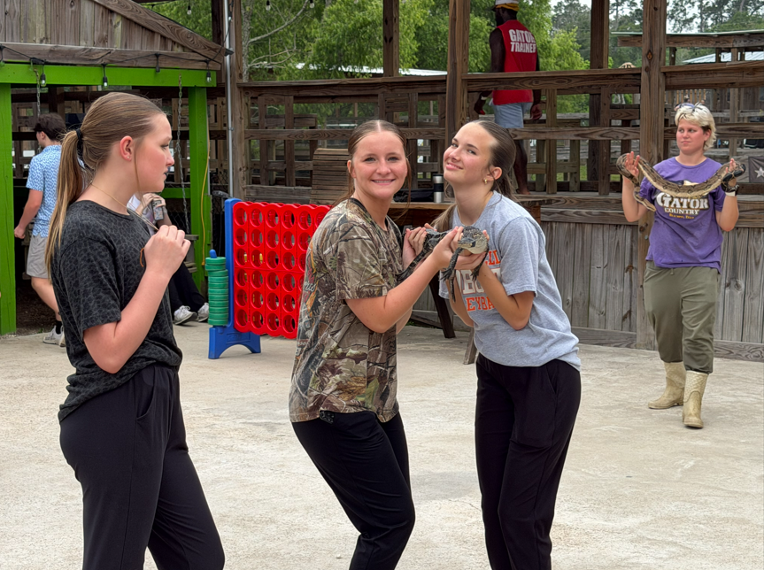 8th graders nervously hold an alligator.