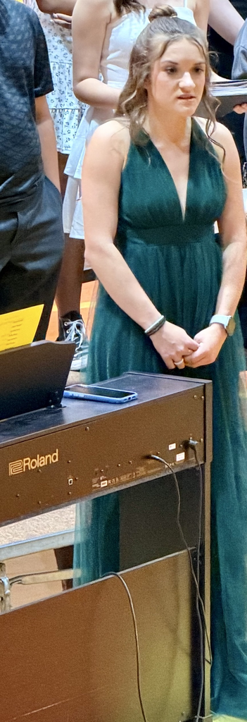 Student in a green dress at a podium  