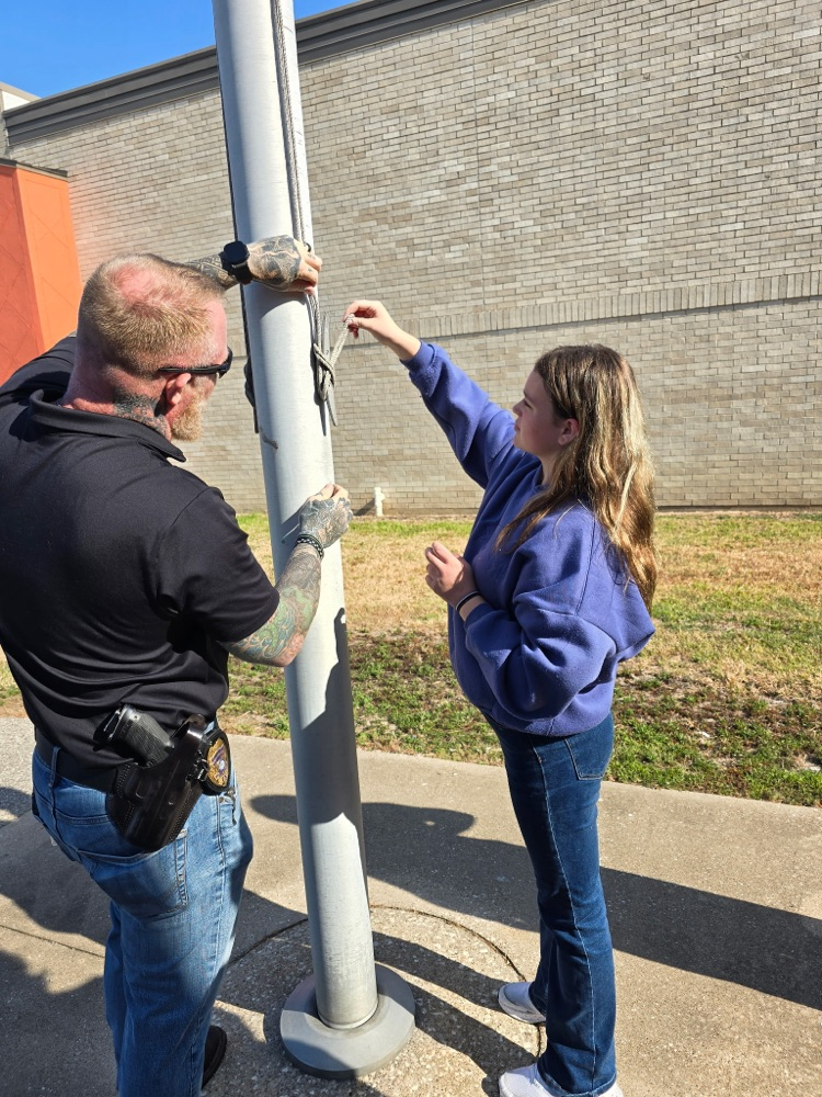Mr. Teague showing the students how to raise/lower the flag.