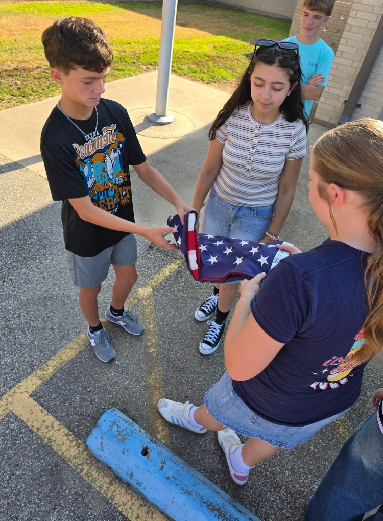 Mr. Teague showing the students how to fold the American flag.