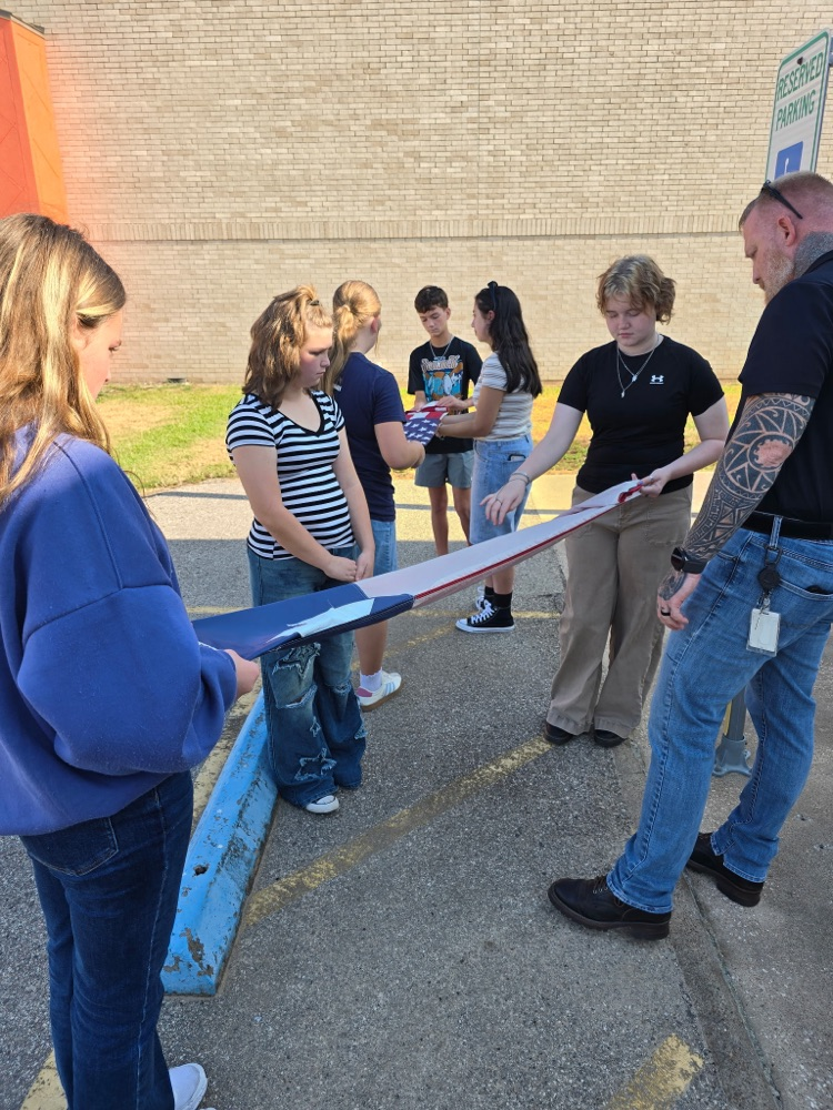 Mr. Teague showing the students how to fold a flag.