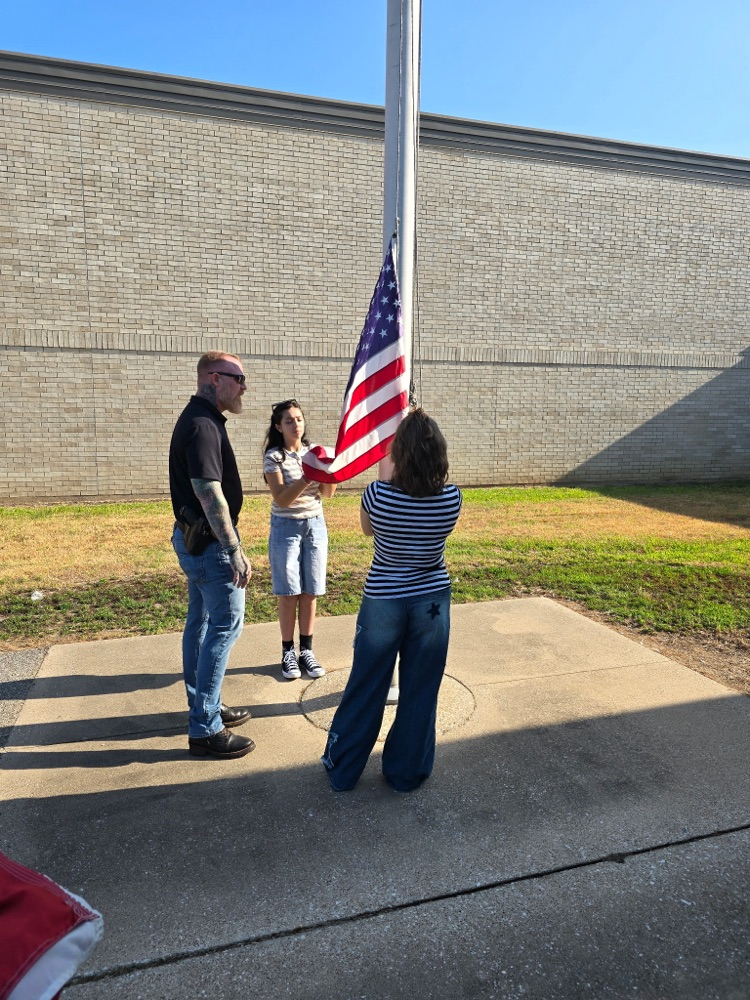 Mr. Teague showing the students how to raise/lower the flag.