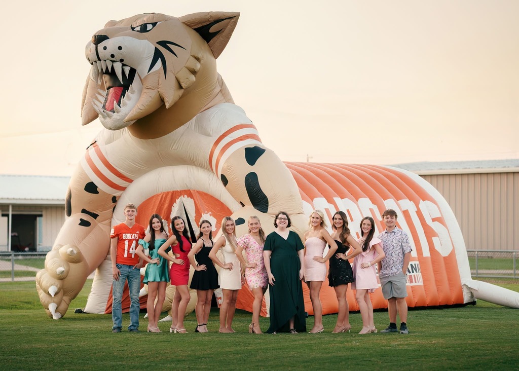 A group of people stands in front of a large inflatable tiger, posing for a photo.