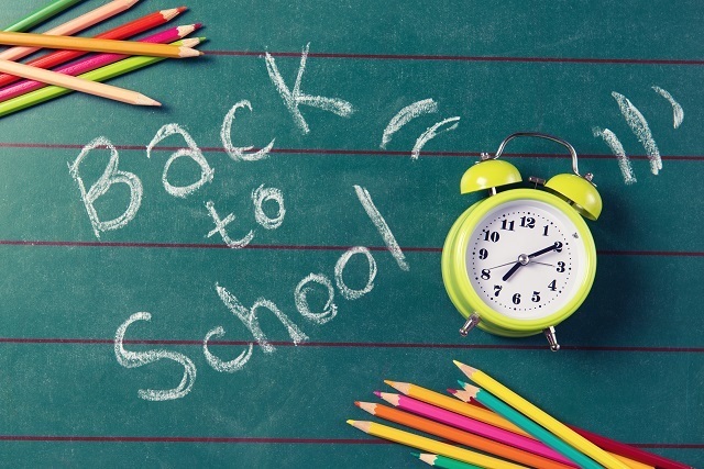back-to-school notepaper, colored pencils, and alarm clock