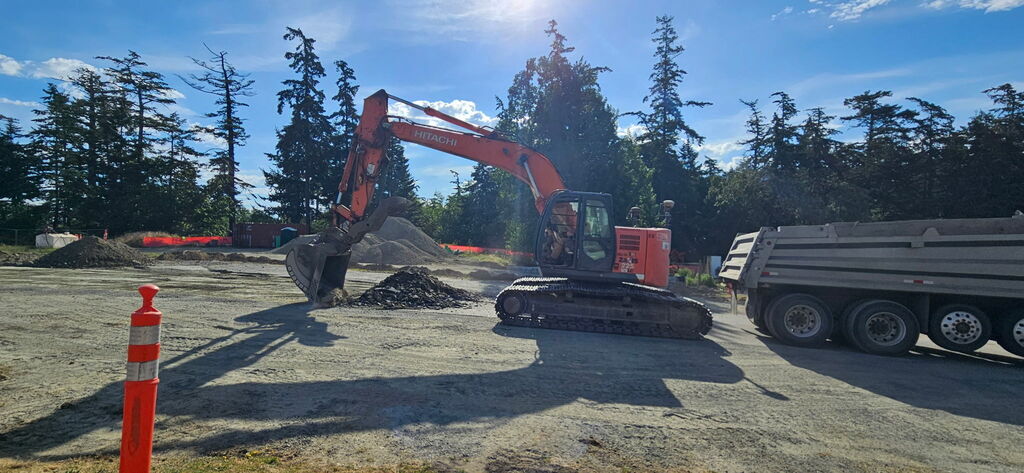 Large construction truck prepping road for new asphalt