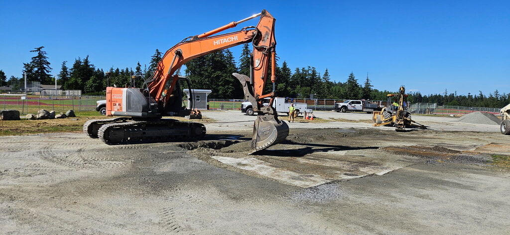 Large construction truck prepping road for new asphalt