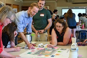 Community Volunteers huddling around a table during 2025 Bond Implementation.
