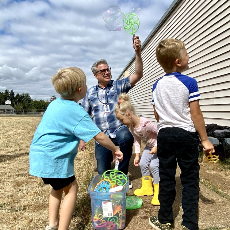 Mr. Dauch blows bubbles with children.