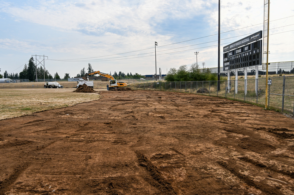 Truck removing dirt from field into dump truck