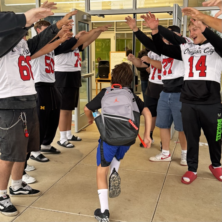 football players welcome students to school 