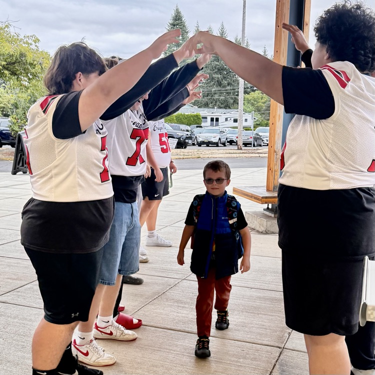 football players welcome students to school 