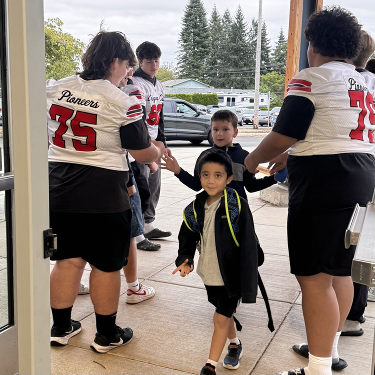 football players welcome students to school 