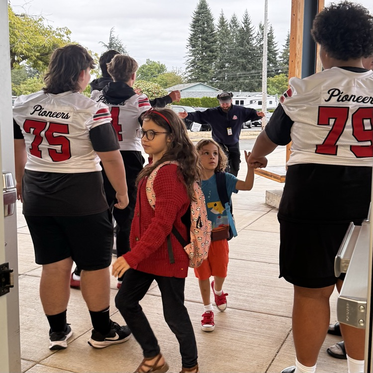 football players welcome students to school 