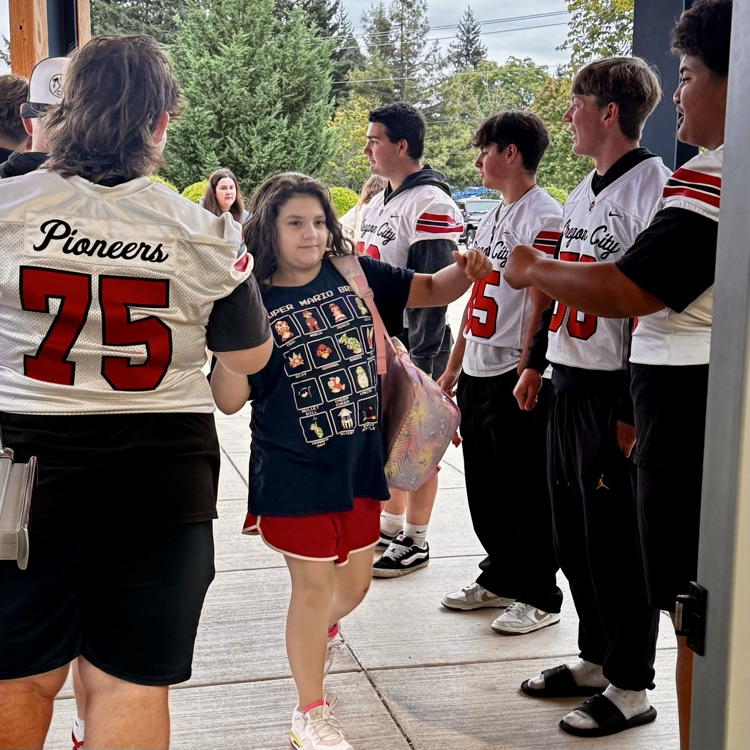 football players welcome students to school 