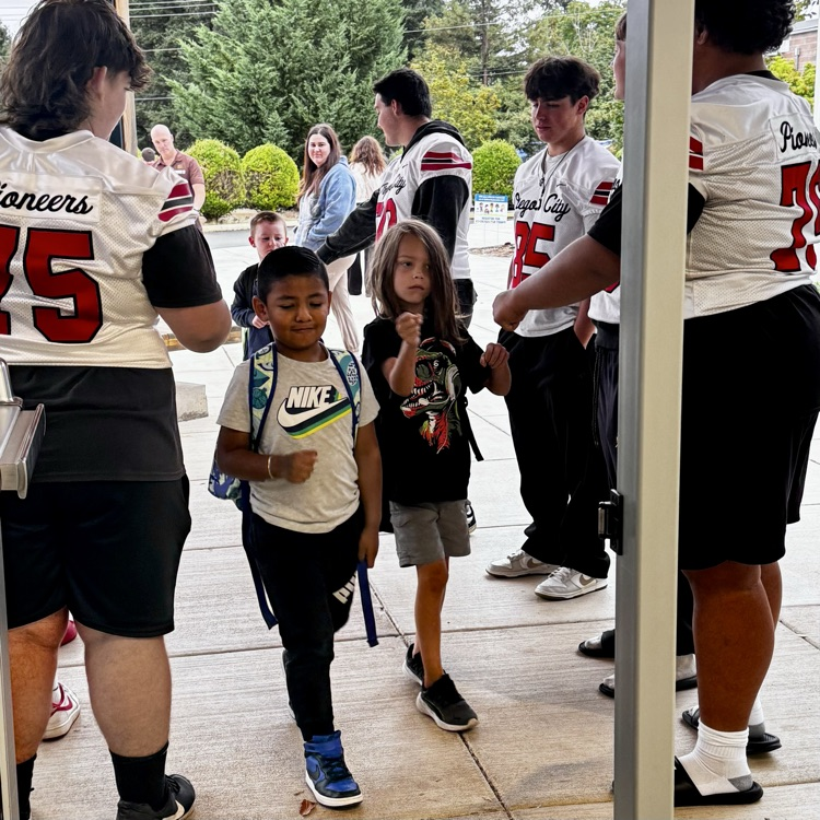 football players welcome students to school 