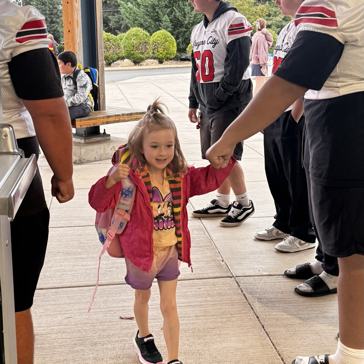 football players welcome students to school 