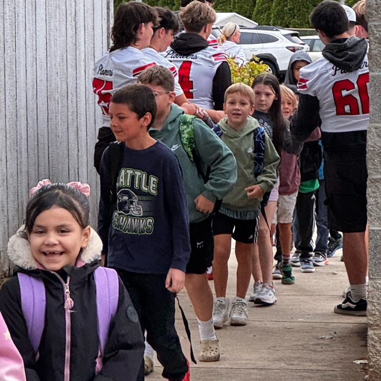 football players welcome students to school 
